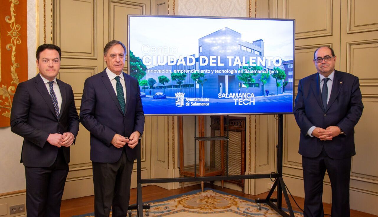 Tres hombres posan junto a una pantalla con el Centro Ciudad del Talento