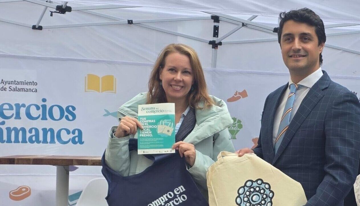 Personas sosteniendo totebags en la Semana del Comercio en Salamanca.