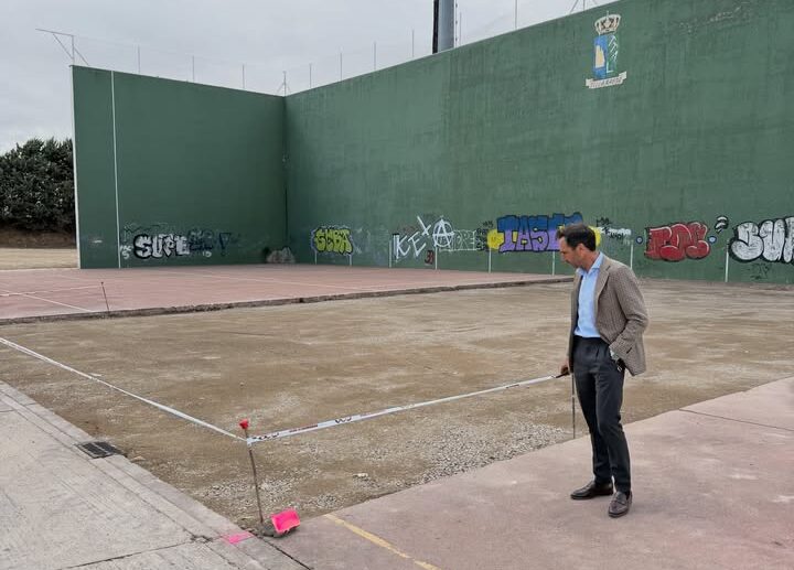 Hombre observando el frontón municipal en Villamayor con obras en curso