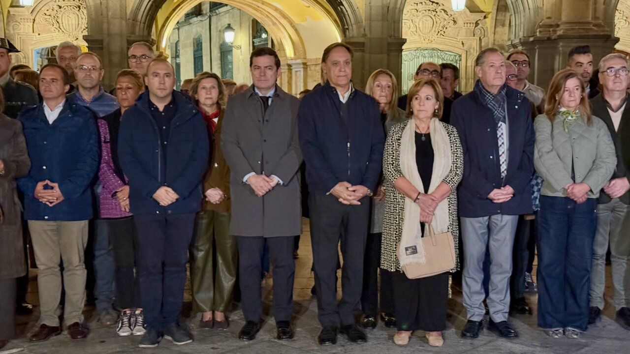 Grupo de personas reunidas bajo arcos de piedra en la entrada de un edificio.