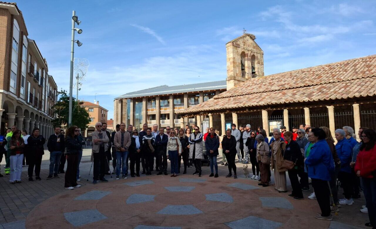 Grupo de personas reunidas en una plaza durante un homenaje en silencio