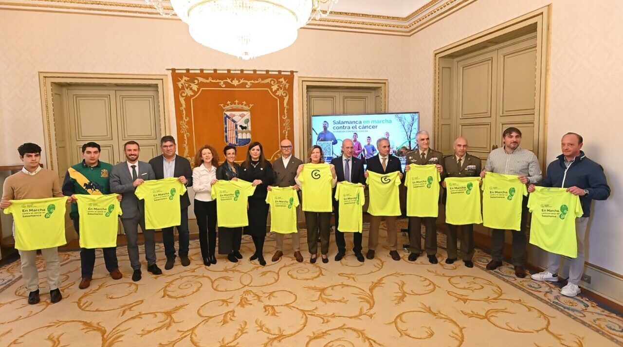 Grupo de personas sostiene camisetas amarillas durante la presentación de la Marcha contra el Cáncer.